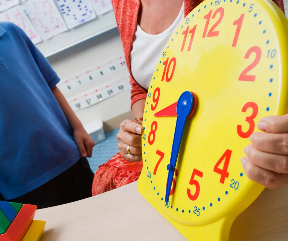 Nauczycielka pokazująca dziecku zegar edukacyjny – nauka przez zabawę zgodna z planem daltońskim w żłobku FreeDom Nursery we Wrocławiu